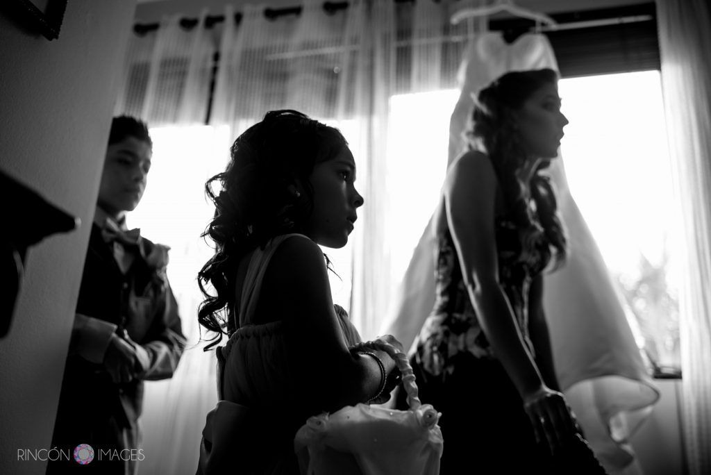 Black and white photograph of a flower girl standing with her brother and sister.
