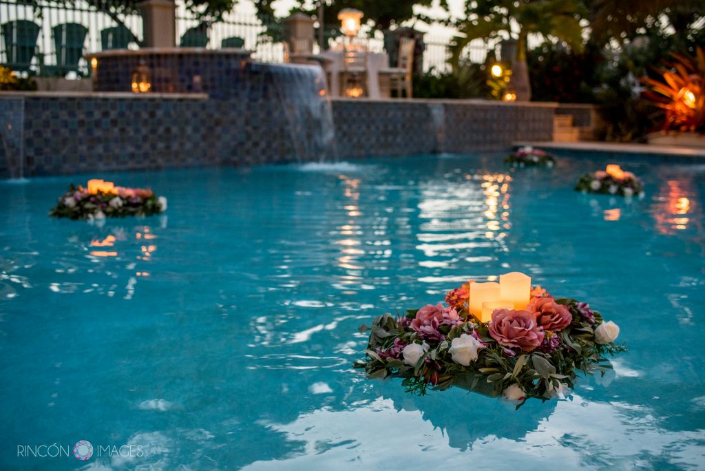Flower arrangements with candles floating in the swimming pool.