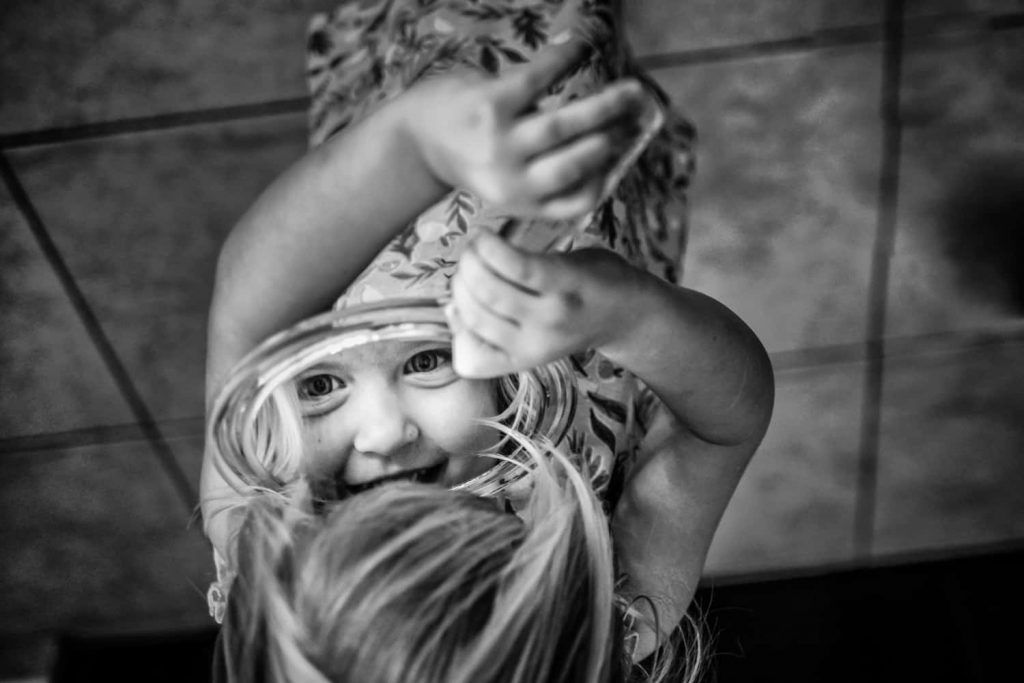Flower girl at a wedding playing with a mirror.