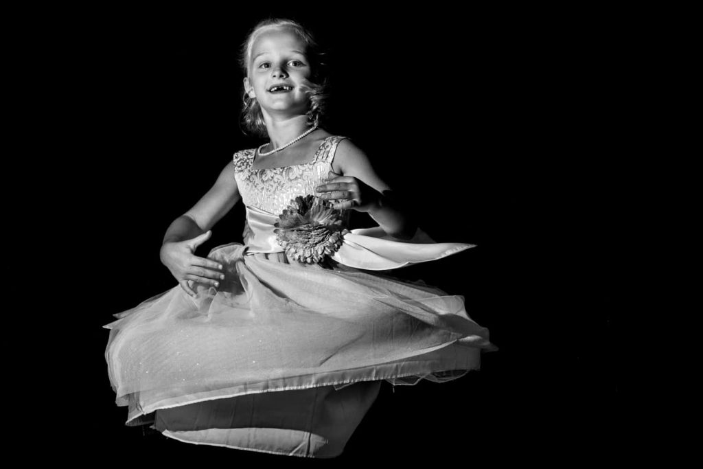 Black and white photograph of flower girl twirling