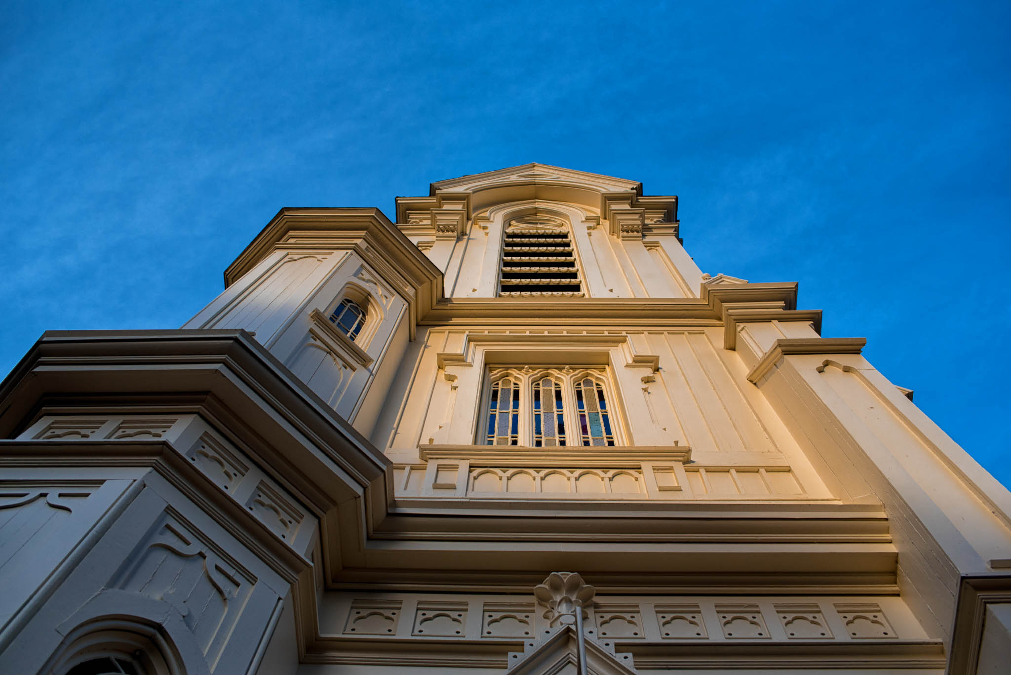 Front of church building with afternoon light and blue sky
