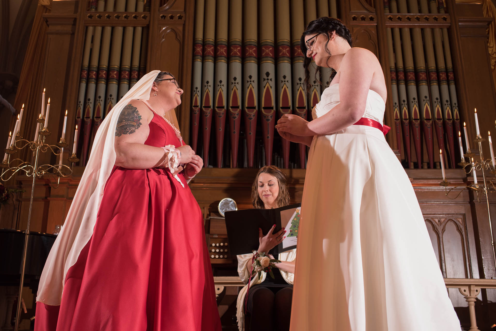 Brides exchanging rings during wedding ceremony