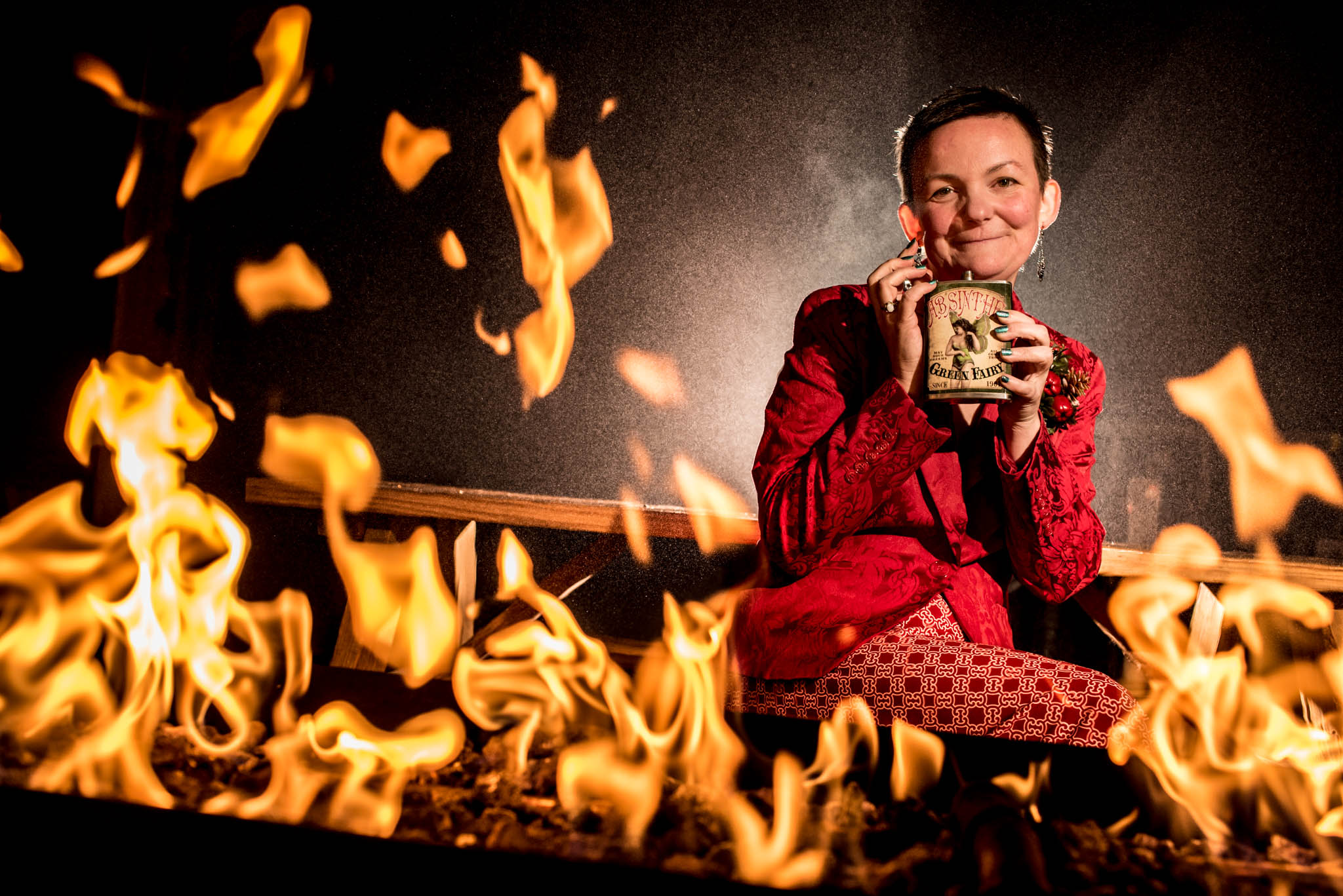 Creative portrait of woman drinking whiskey in front of the fire