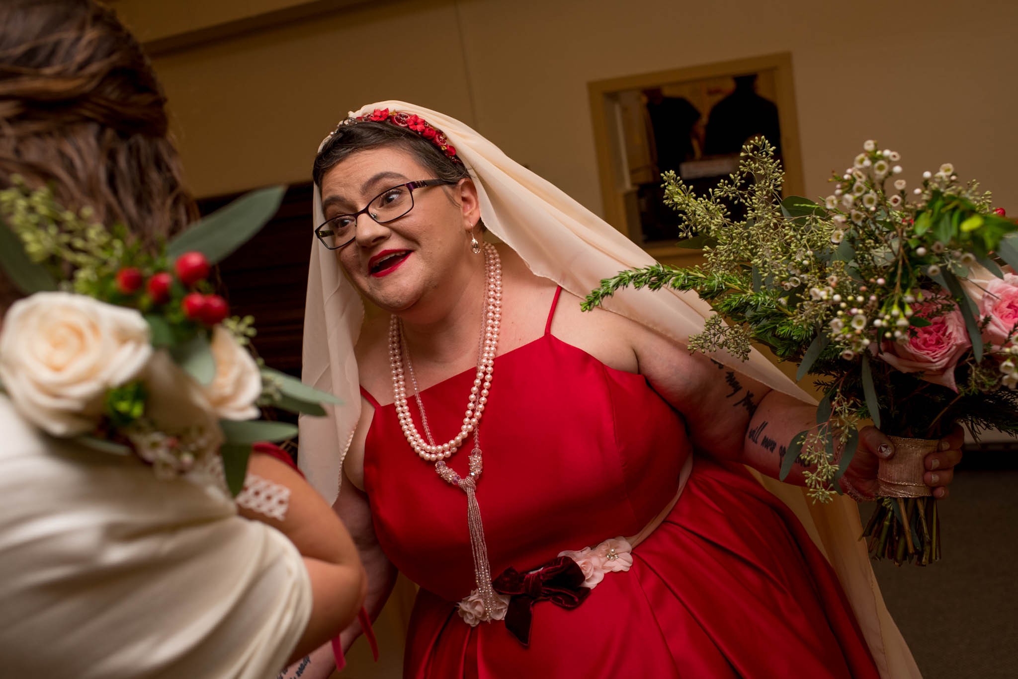 Bride wearing red dress holding bouquet