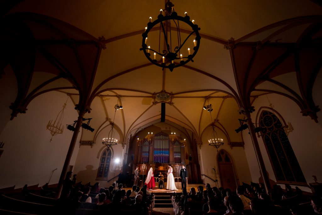 Two brides standing in the Old Church in Portland Oregon during their wedding ceremony