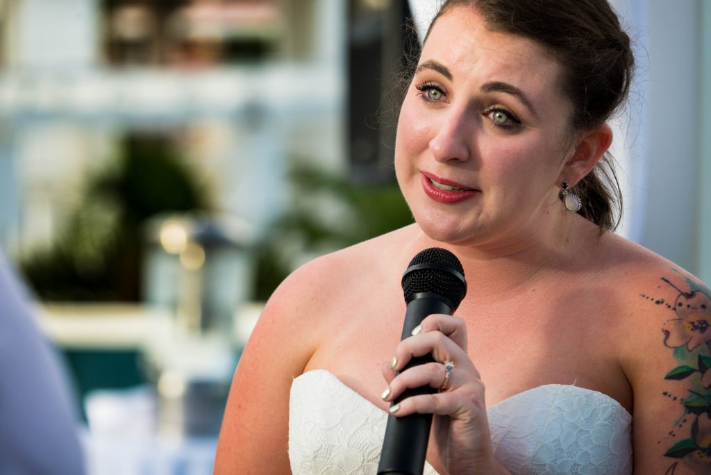 Close up photograph of teary eyed bride reading her vows.