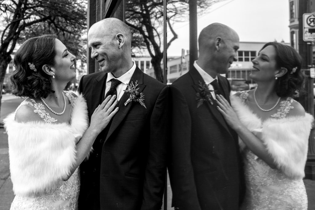 Bride and groom with their reflection in a window in Portland, Oregon