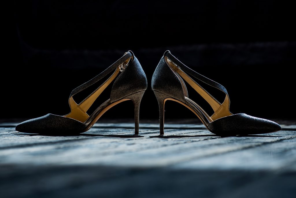 Brides silver wedding shoes on a wooden floor