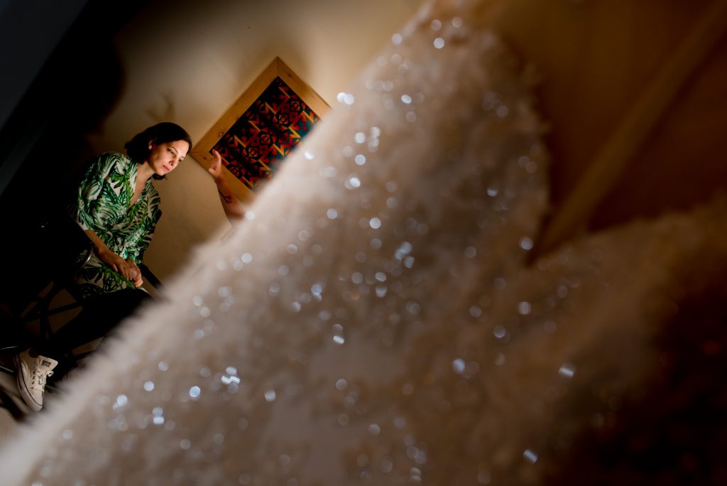 Bride having her make up done with her wedding dress in the foreground