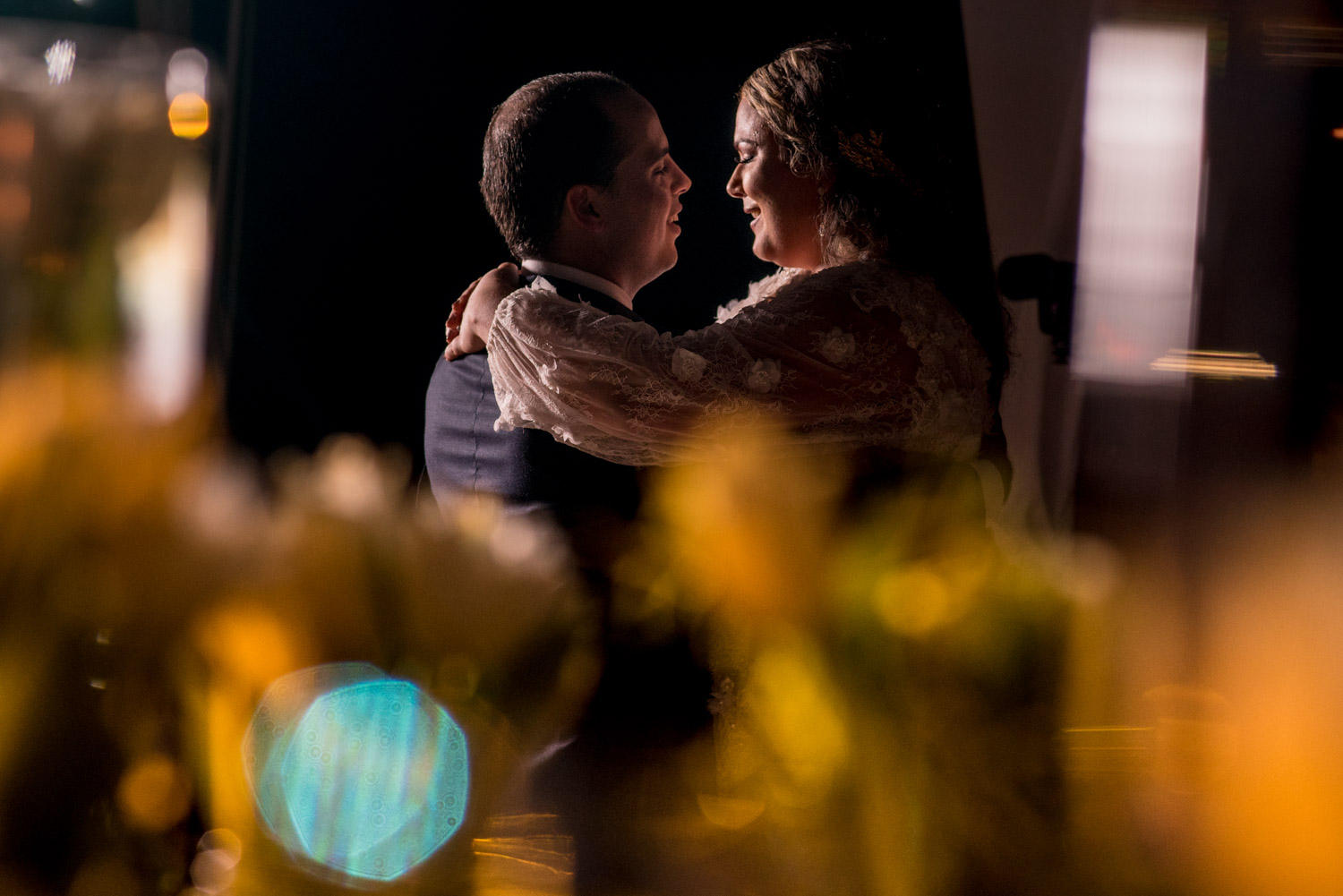 Couple dancing during wedding reception with foreground bokeh