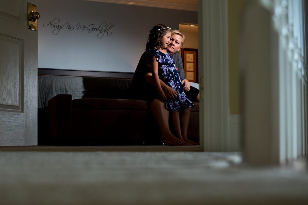 Woman having a moment with her neice in front of a sign that says "Always kiss goodnight"