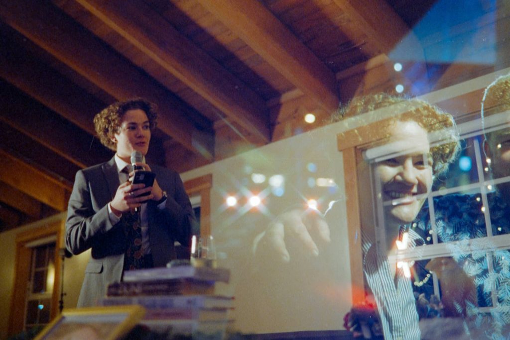 Double exposure shot of a speech at the reception in Loft at The Red Building, Oregon combined with a picture of the wedding guest superimposed.