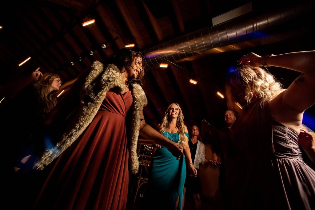 Warm's eye view of the bridal party enjoying the dance floor during the reception in The Loft at The Red Building in Astoria, Oregon.