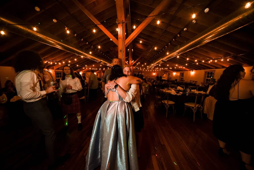 The bride hugging a guest at the reception in The Loft at The Red Building in Astoria, Oregon.