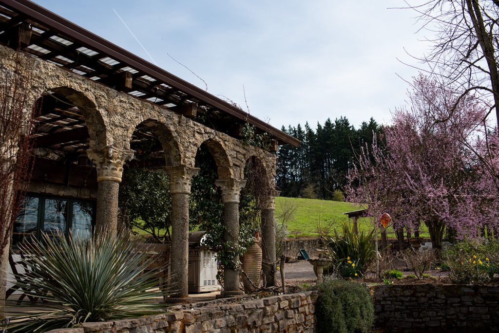 a stone building with arches and plants in front of it.