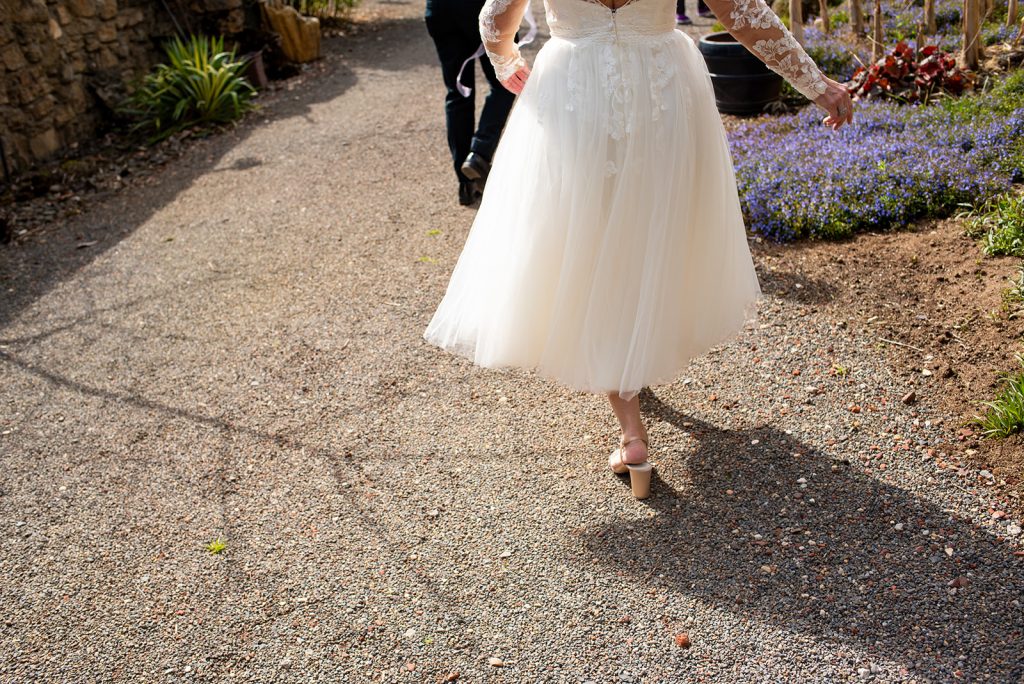 a woman in a white dress walking down a path.