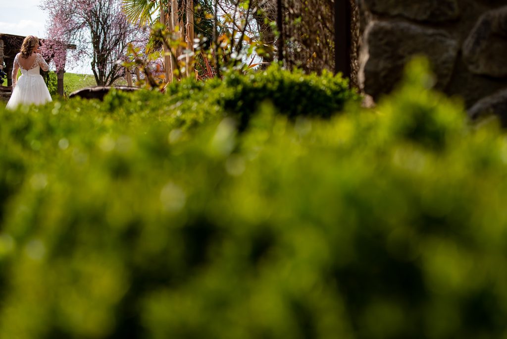 a woman in a wedding dress standing in a garden.