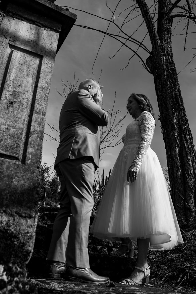 a man and a woman standing next to a tree during the first look moment of a wedding