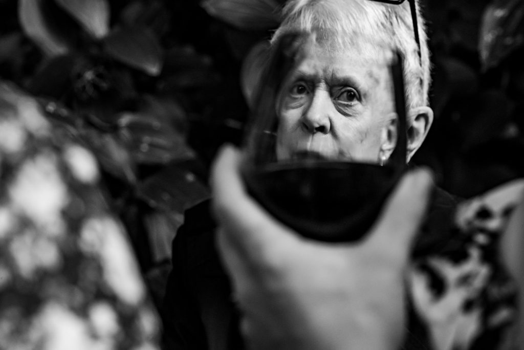 A womans face distorted as seen through a wine glass