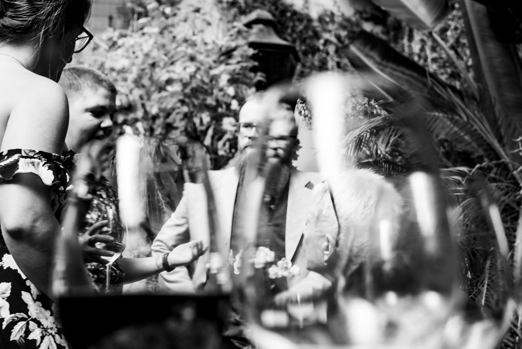 a group of people standing around a table with wine glasses.