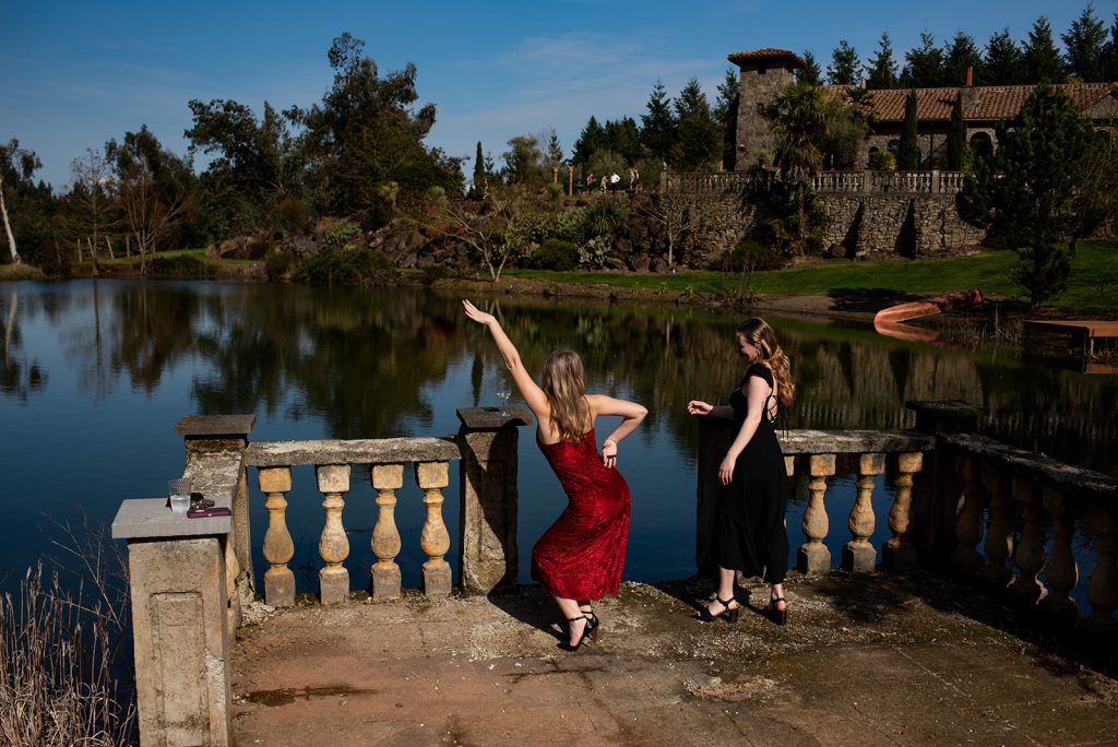 a couple of women standing next to a body of water.