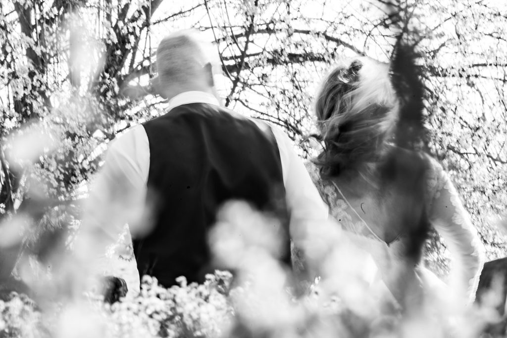 a man and a woman walking through a forest.
