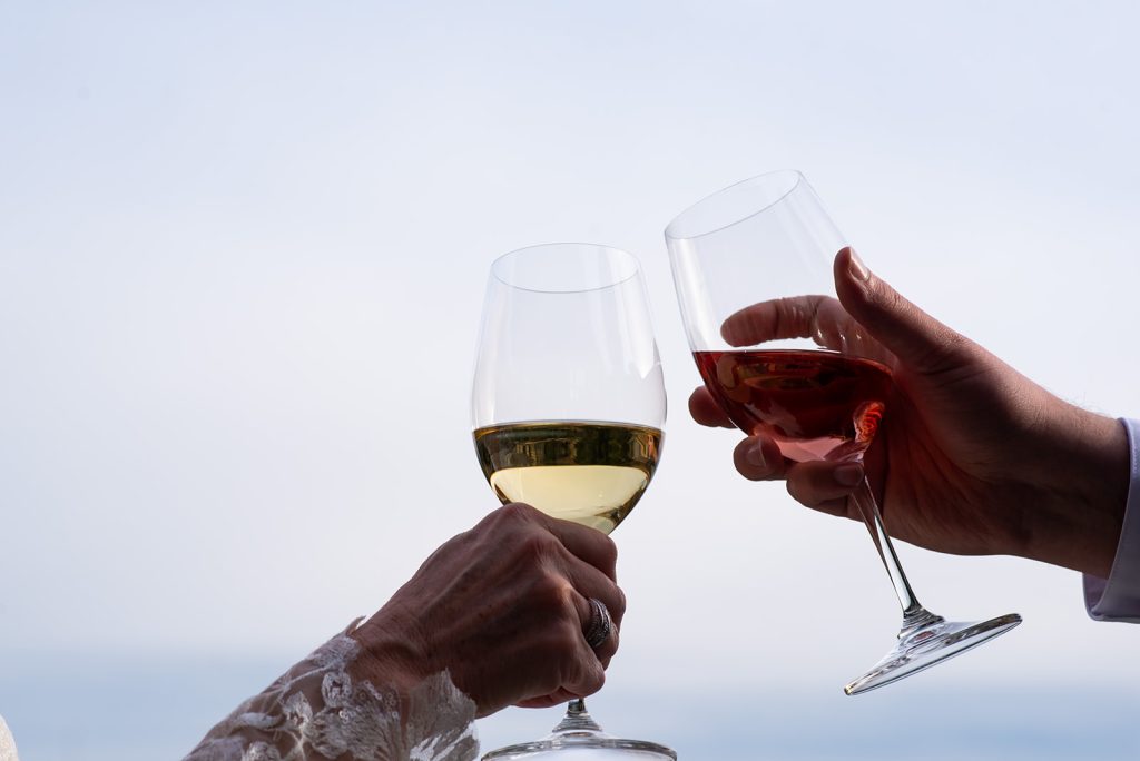 a couple of people holding glasses of wine.