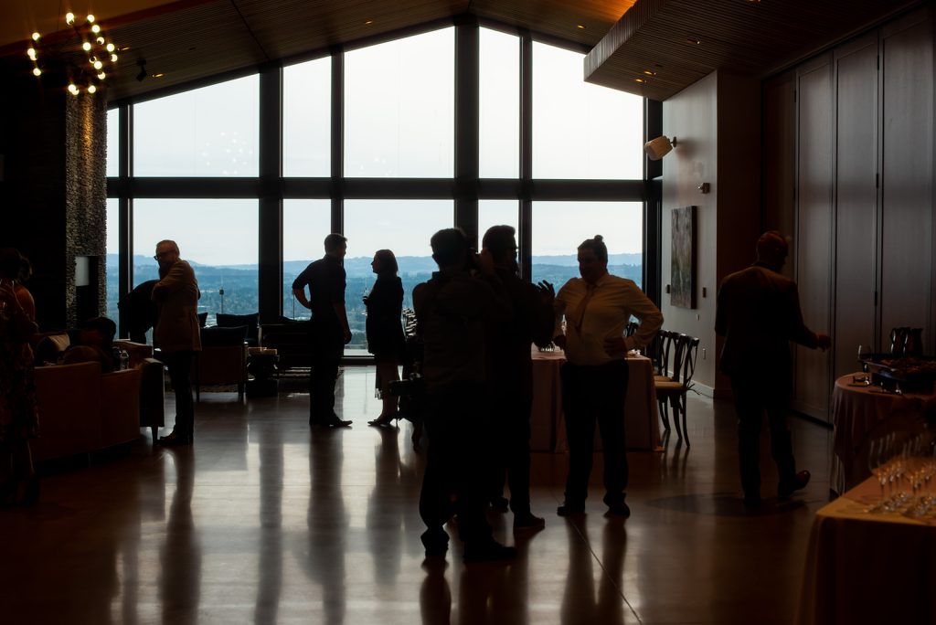 a group of people standing in front of a large window.