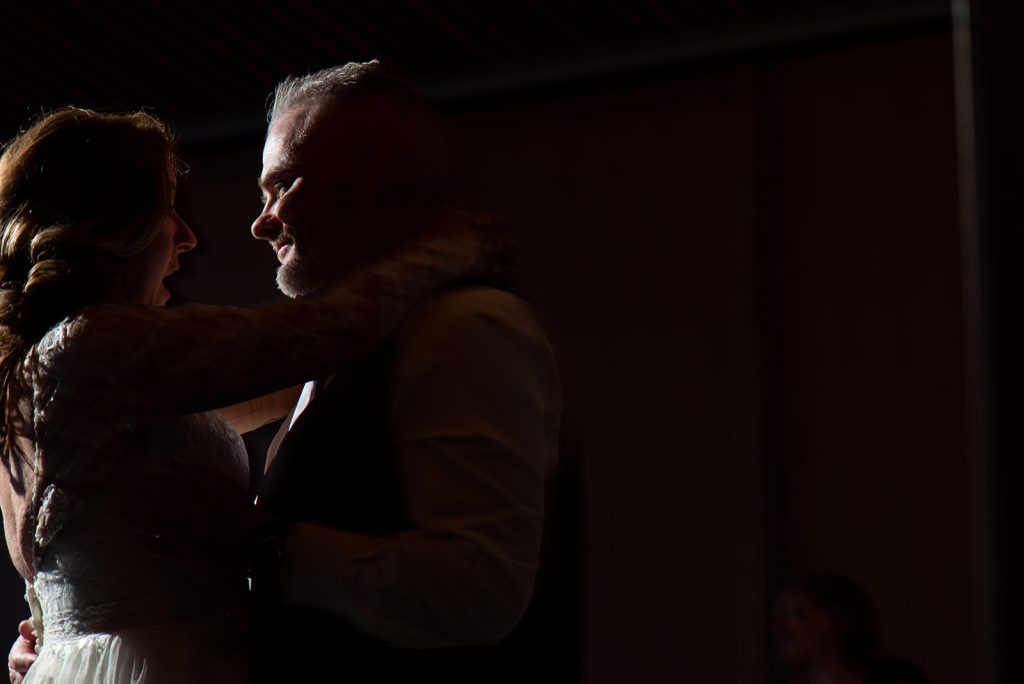 a man and a woman dance together in a dark room.