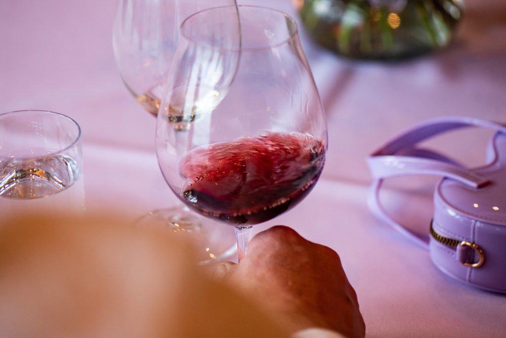 a close up of a person holding a wine glass.