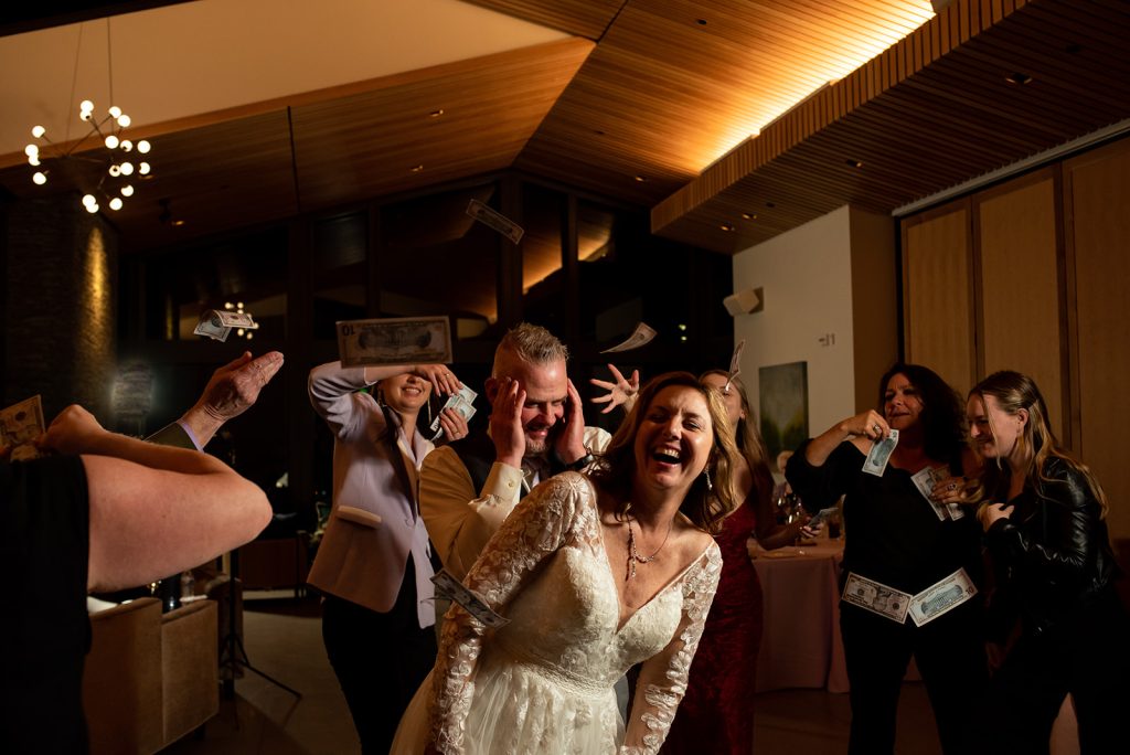 a group of people taking pictures of a bride and groom and throwing money
