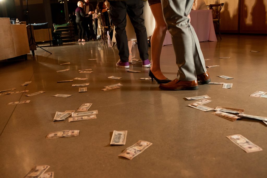 a group of people standing on top of a floor covered in money.