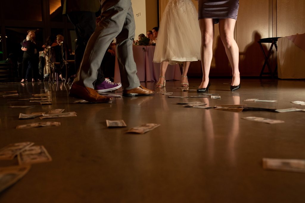 a group of people standing on top of a wooden floor doing a money dance