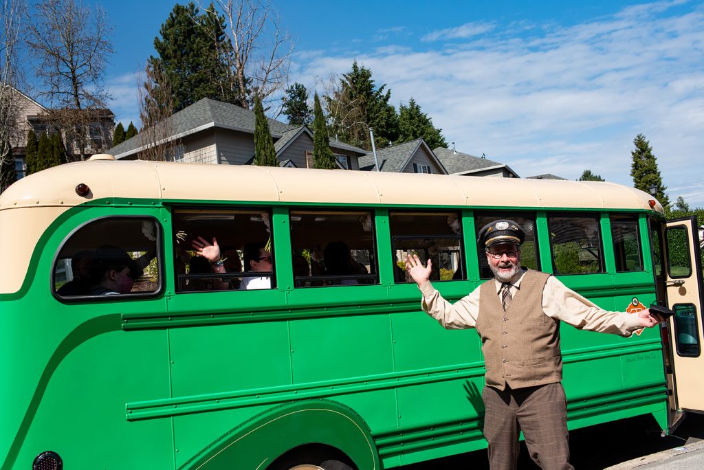 a man standing in front of a green bus.