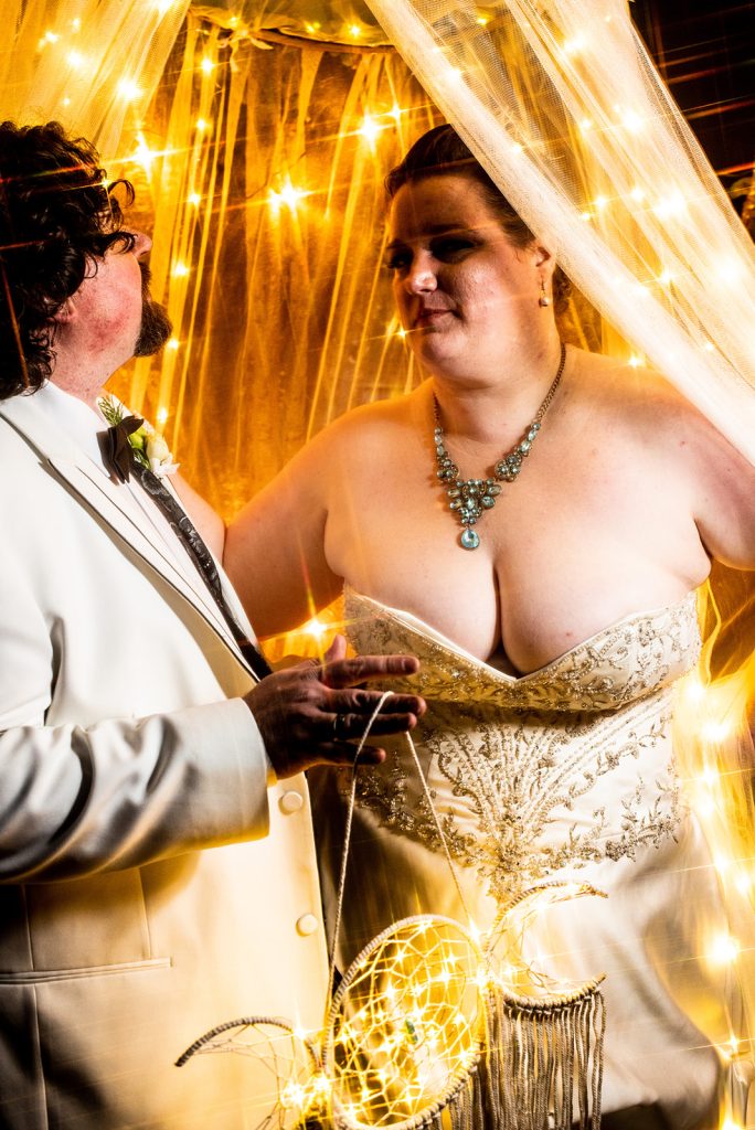 Intimate moment between bride and groom at a yellow-hued evening celebration